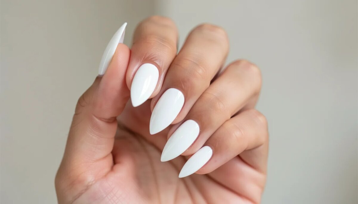 Mão feminina com unhas de fibra branca em formato amendoado, acabamento brilhante e natural.